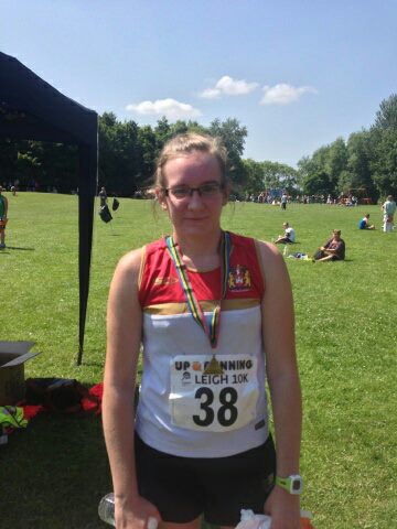 Running journey begins - girl with finishing medal after 10k race