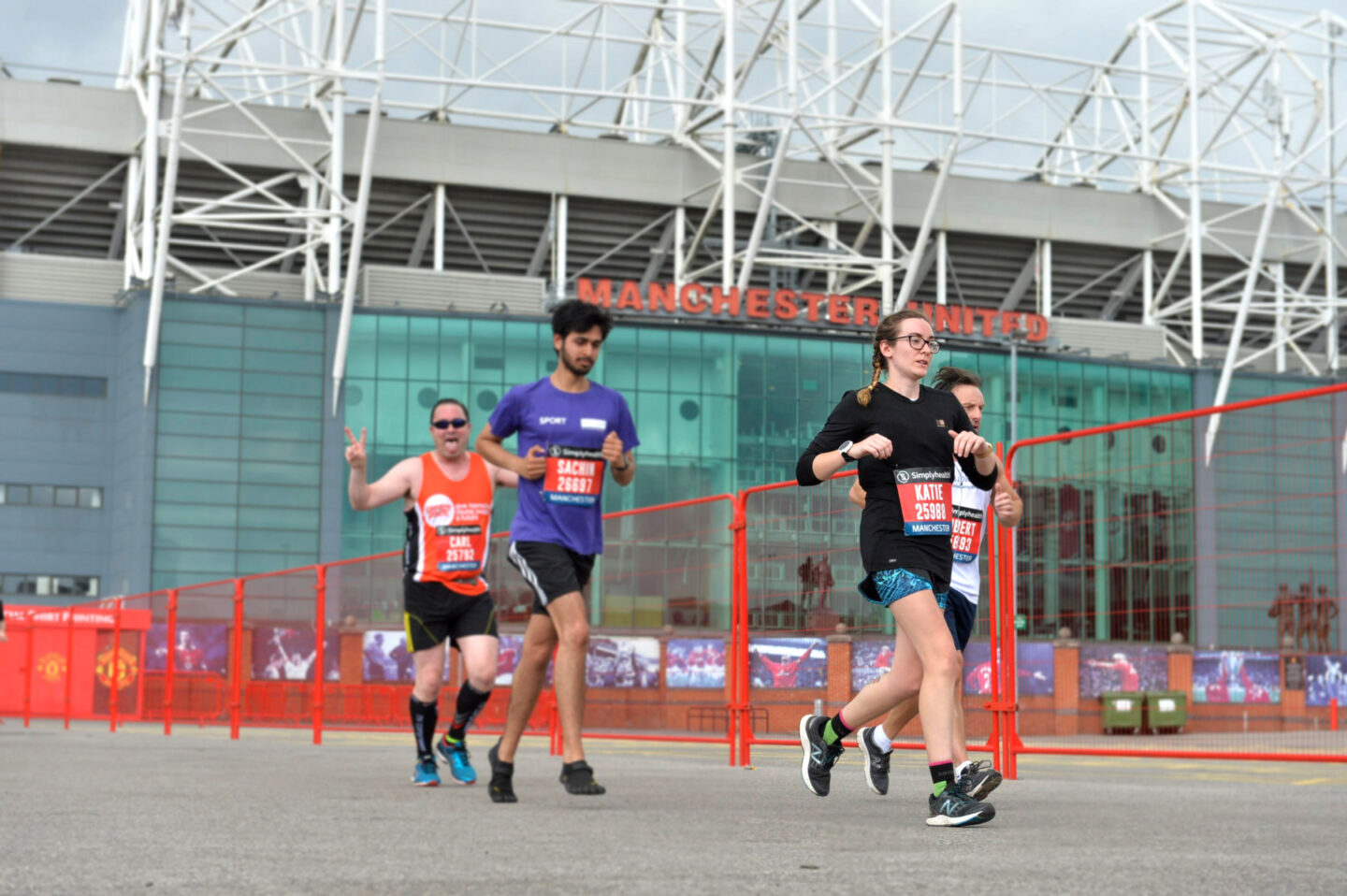 People running in front of old trafford stadium in Great Manchester Run Half Marathon event.