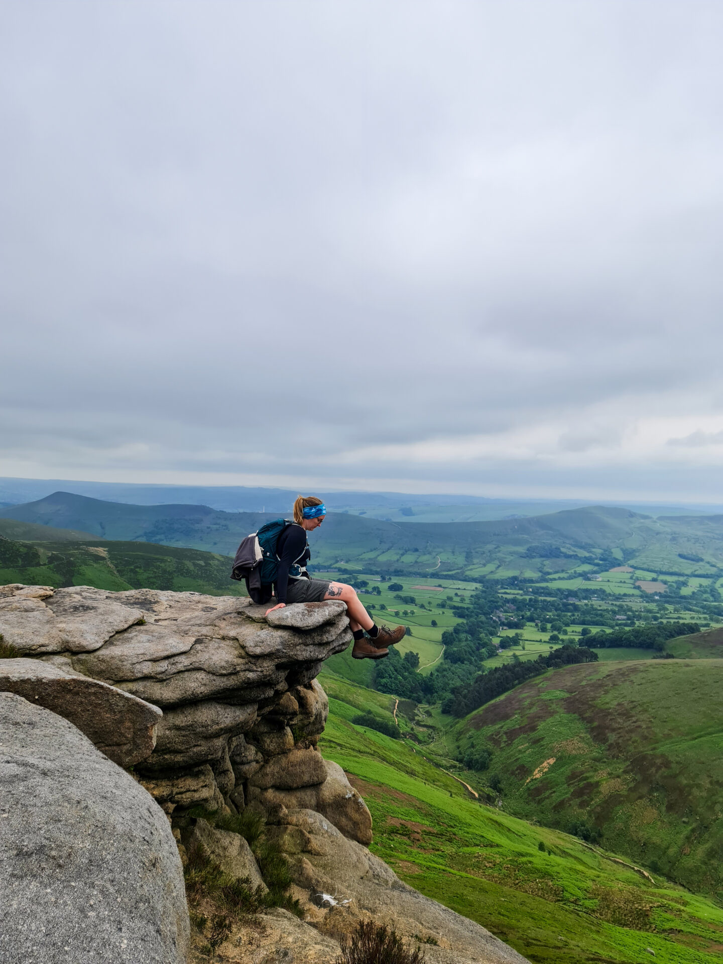 Girl sat on rock with hiking view in the distance