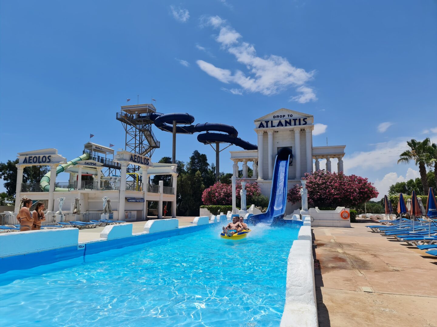 Three people have just splashed int the pool after sliding down the drop to atlantis